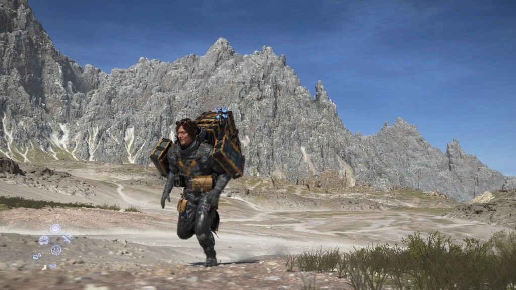 Sam running with a large stack of cargo through a rocky valley