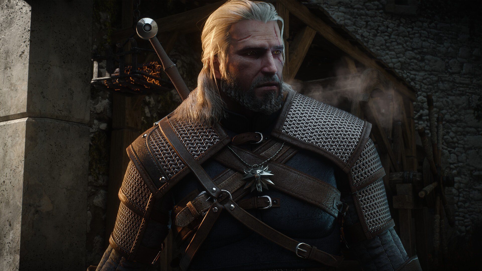 Geralt of Rivia in chainmail standing in dim light in The Witcher 3 Remastered